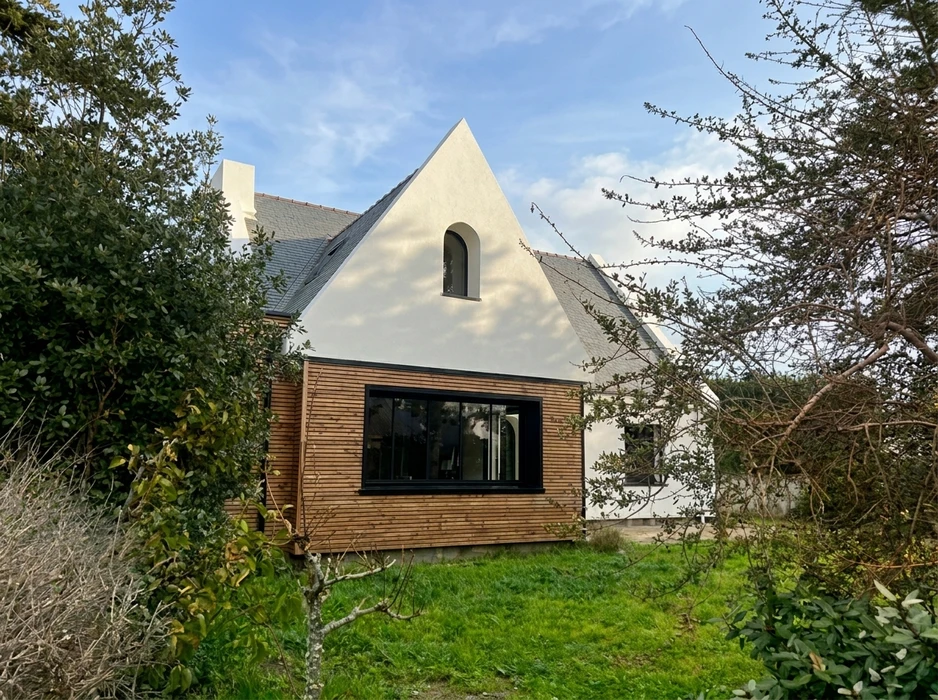 Maison rénovée vue de jardin, extension contemporaine en bardage bois horizontal naturel, large baie vitrée noire