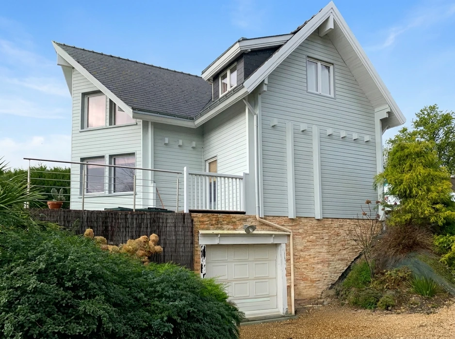 Maison individuelle à ossature bois, bardage horizontal gris-bleu clair, toiture en ardoise grise