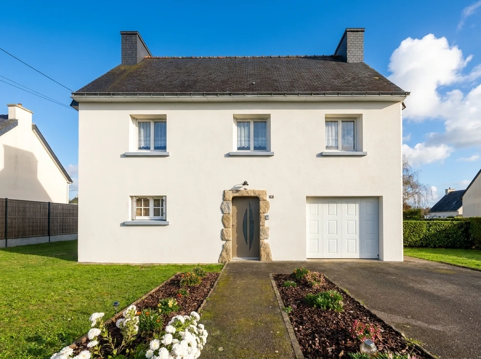 Maison individuelle pavillonnaire de style breton, façade enduit blanc, toiture en ardoise à quatre pans avec deux souches de cheminée