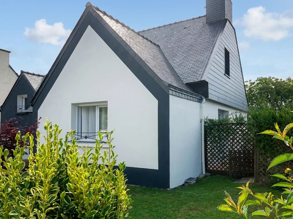 Maison individuelle rénovée, façade blanche avec encadrements anthracite, toiture en ardoise naturelle