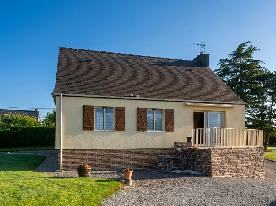 Maison pavillonnaire de plain-pied avec combles, façade enduit beige, soubassement en brique et pierre apparente