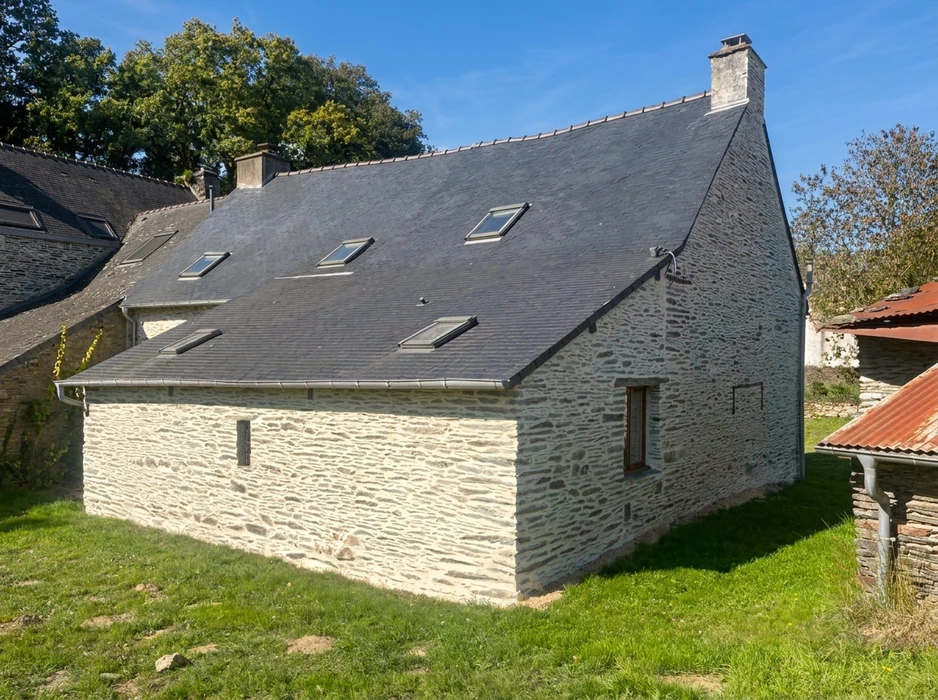 Maison en pierre de taille rénovée, vue extérieure, toiture en ardoise naturelle avec fenêtres de toit VELUX type GGL, faîtage et noues en zinc
