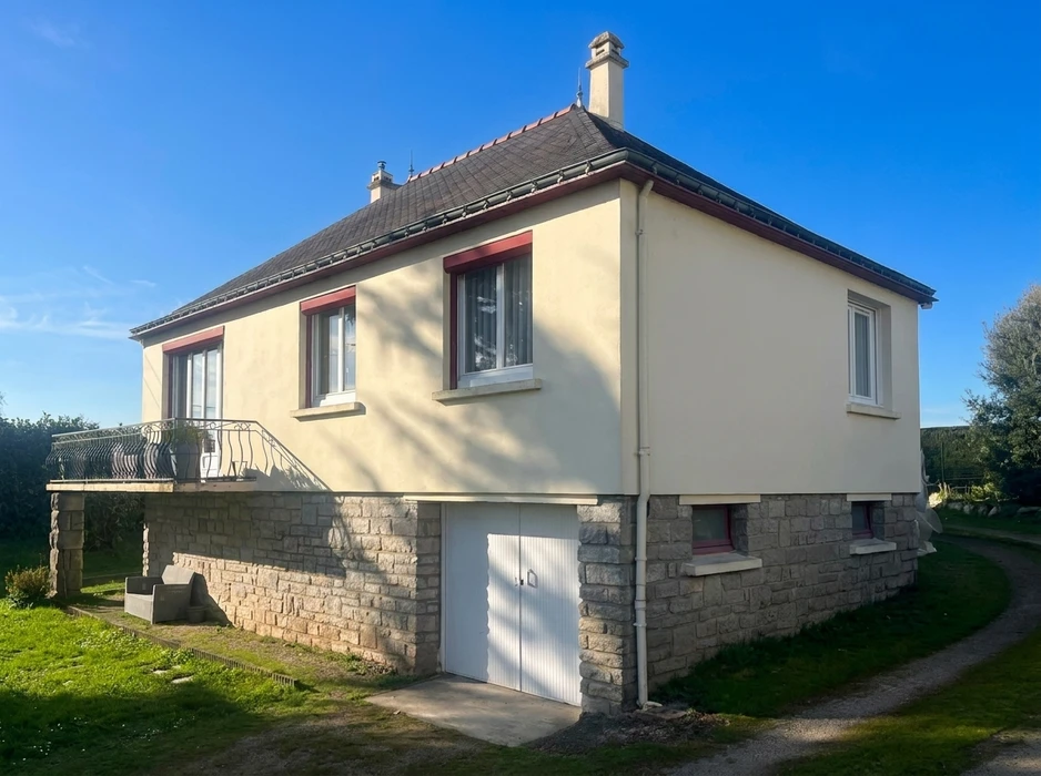 Maison pavillonnaire de plain-pied surélevée, façade enduit beige avec encadrements de fenêtres bordeaux, toiture ardoise à quatre pans avec cheminée