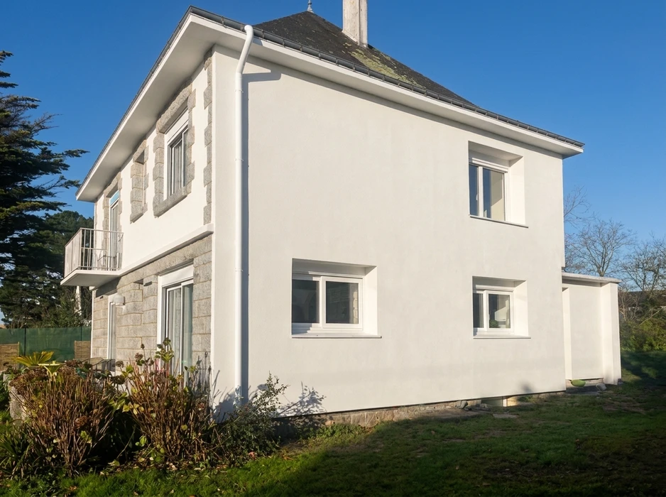 Maison individuelle de deux étages, façade enduite blanche avec encadrements en granite apparents
