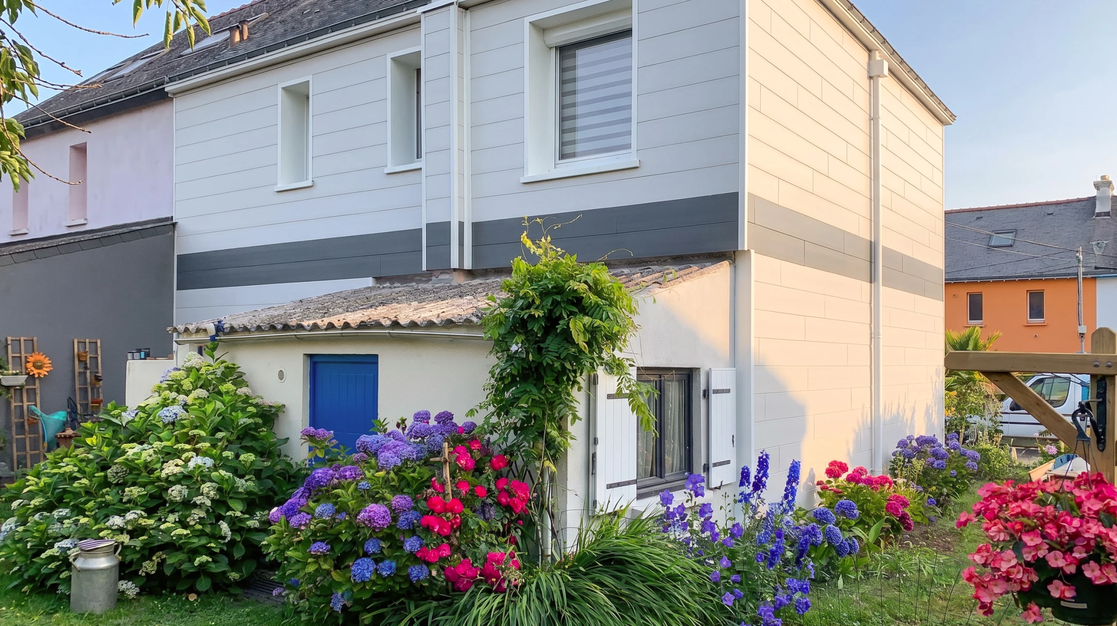 Façade extérieure d'une maison résidentielle moderne avec bardage horizontal bleu foncé et garnitures blanches