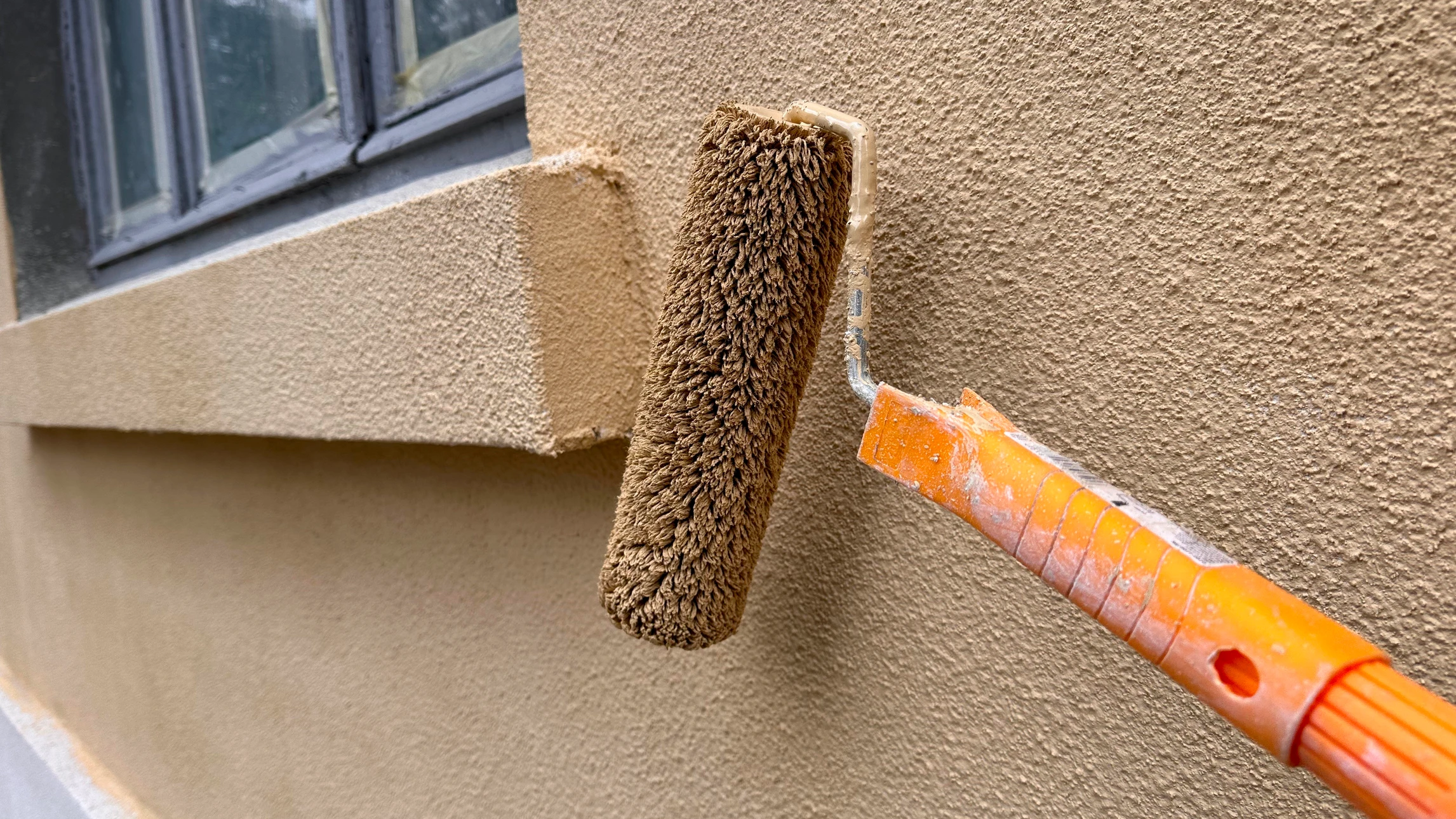 Ouvrier en construction appliquant des panneaux d'isolation thermique sur mur extérieur