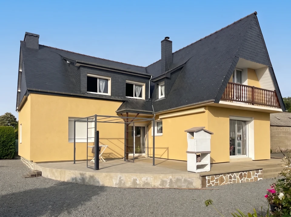 Intérieur de maison en construction avec murs en béton brut, cloisons en briques alvéolaires rouges apparentes